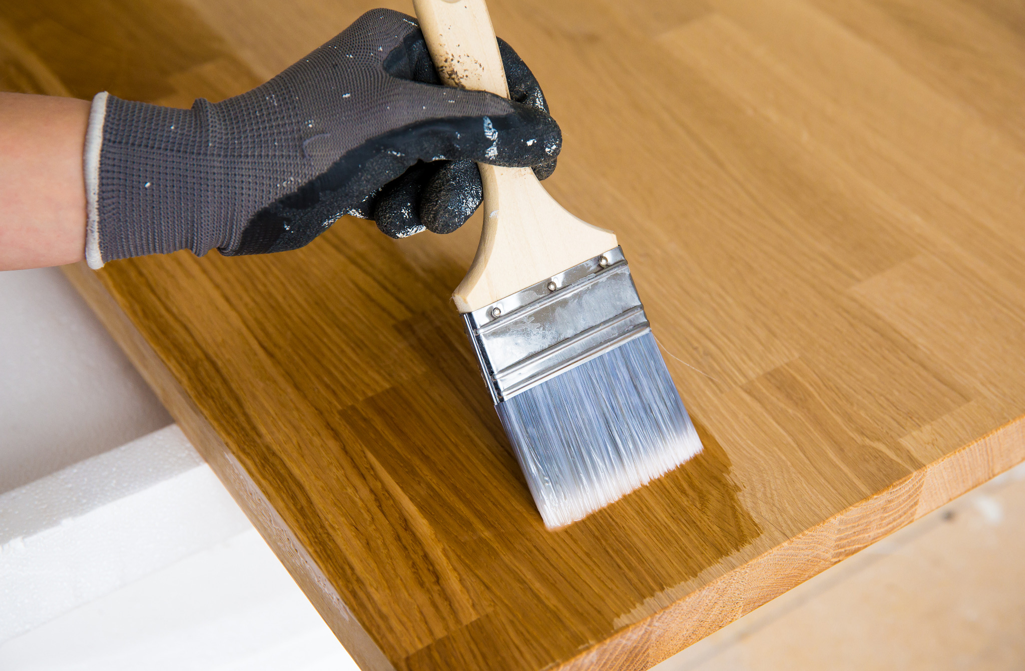 Worktop refinishing in South West London on a solid oak kitchen worktop, showing fresh clear finish being applied for a smooth modern surface.