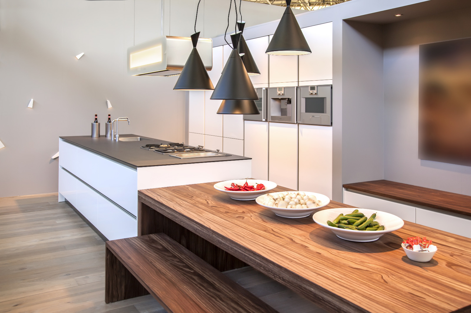 Modern kitchen after Worktop Refinishing in South West London, with rich walnut worktops and bench seating above a light engineered oak plank floor.