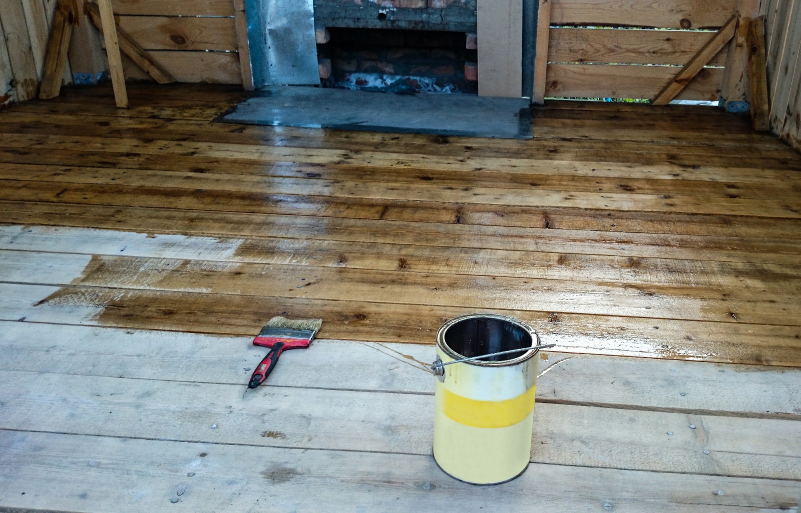 Wood Floor Sanding in South West London living room with varnish being applied to freshly sanded pine floorboards softwood around an old fireplace